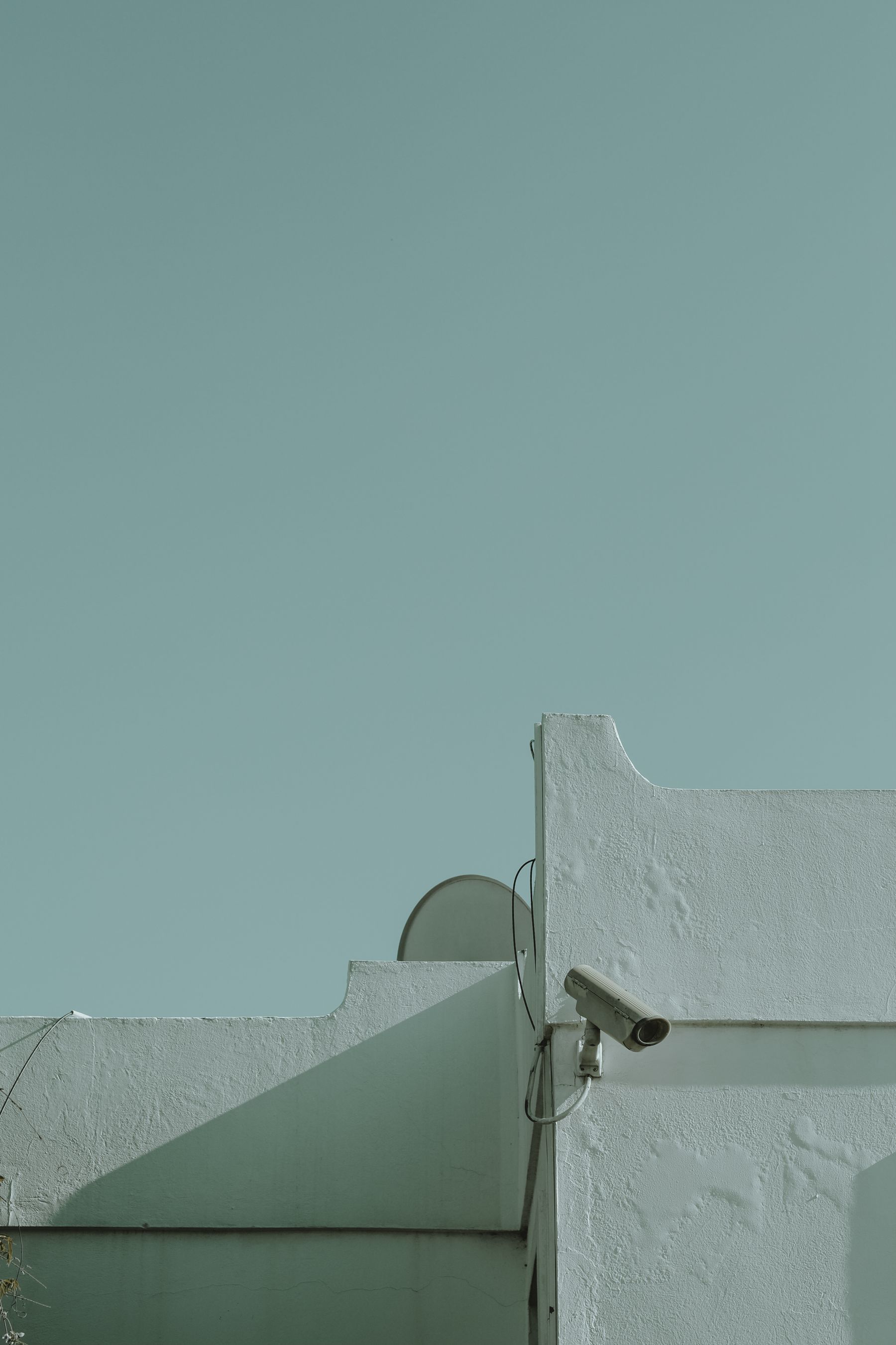 Surveillance camera and cabling mounted on a building wall